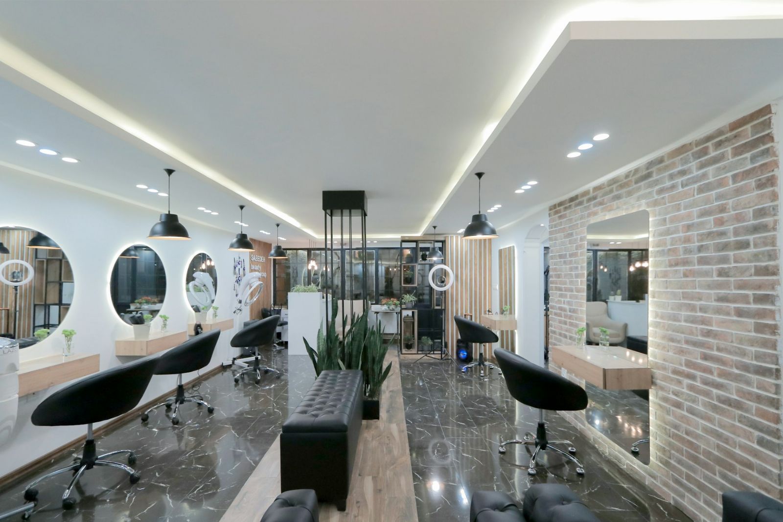 A modern salon interior with styling stations, ring-lit mirrors, and chairs