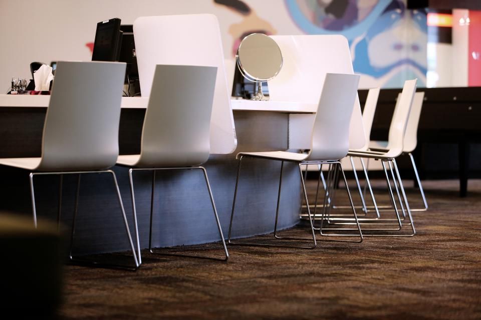 A salon reception area with styling chairs and a counter mirror