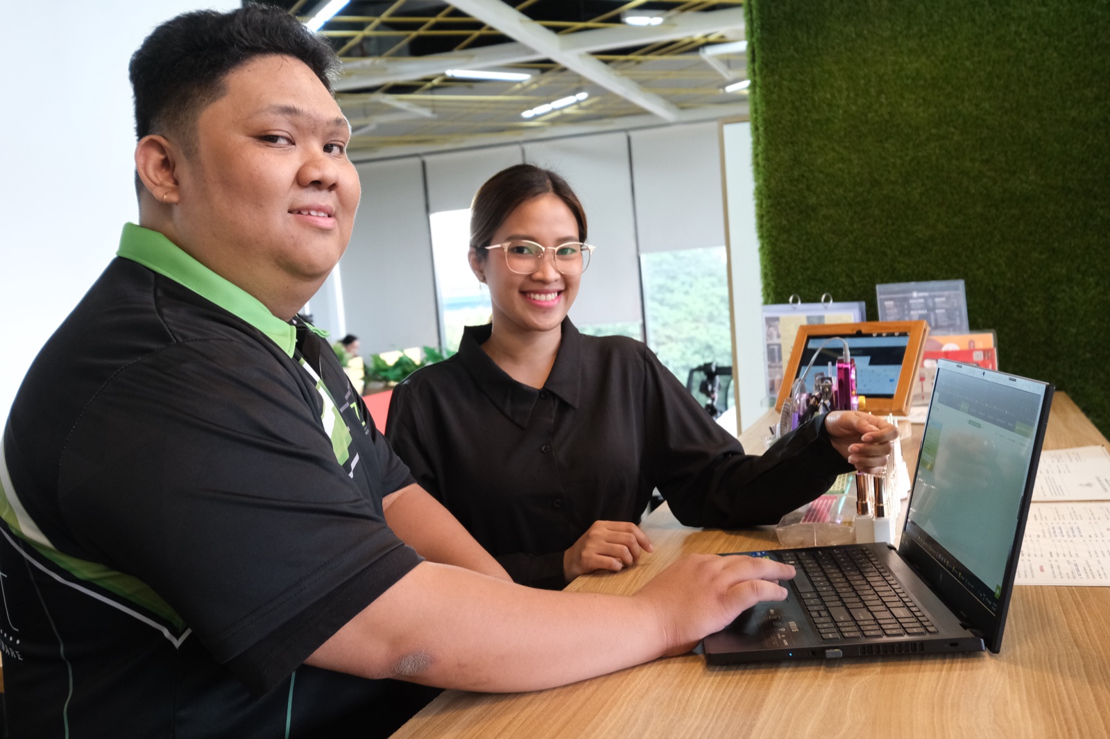 Two ZenSoft team members at a service counter with ZenSoft open on a laptop