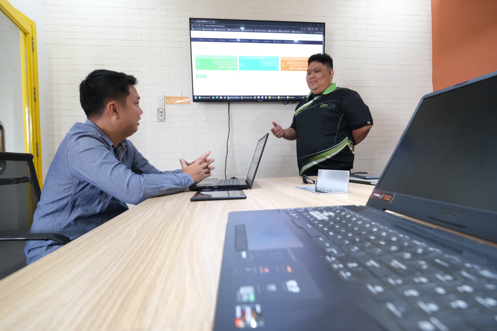 A ZenSoft team member presenting the ZenSoft dashboard on a wall screen