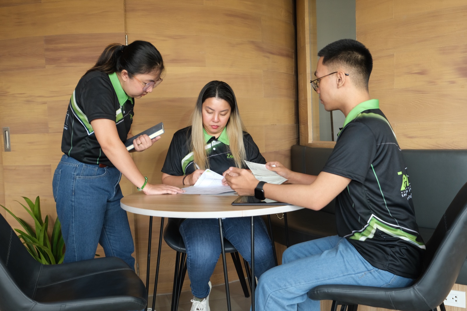 Three ZenSoft team members going through printed reports at a meeting table
